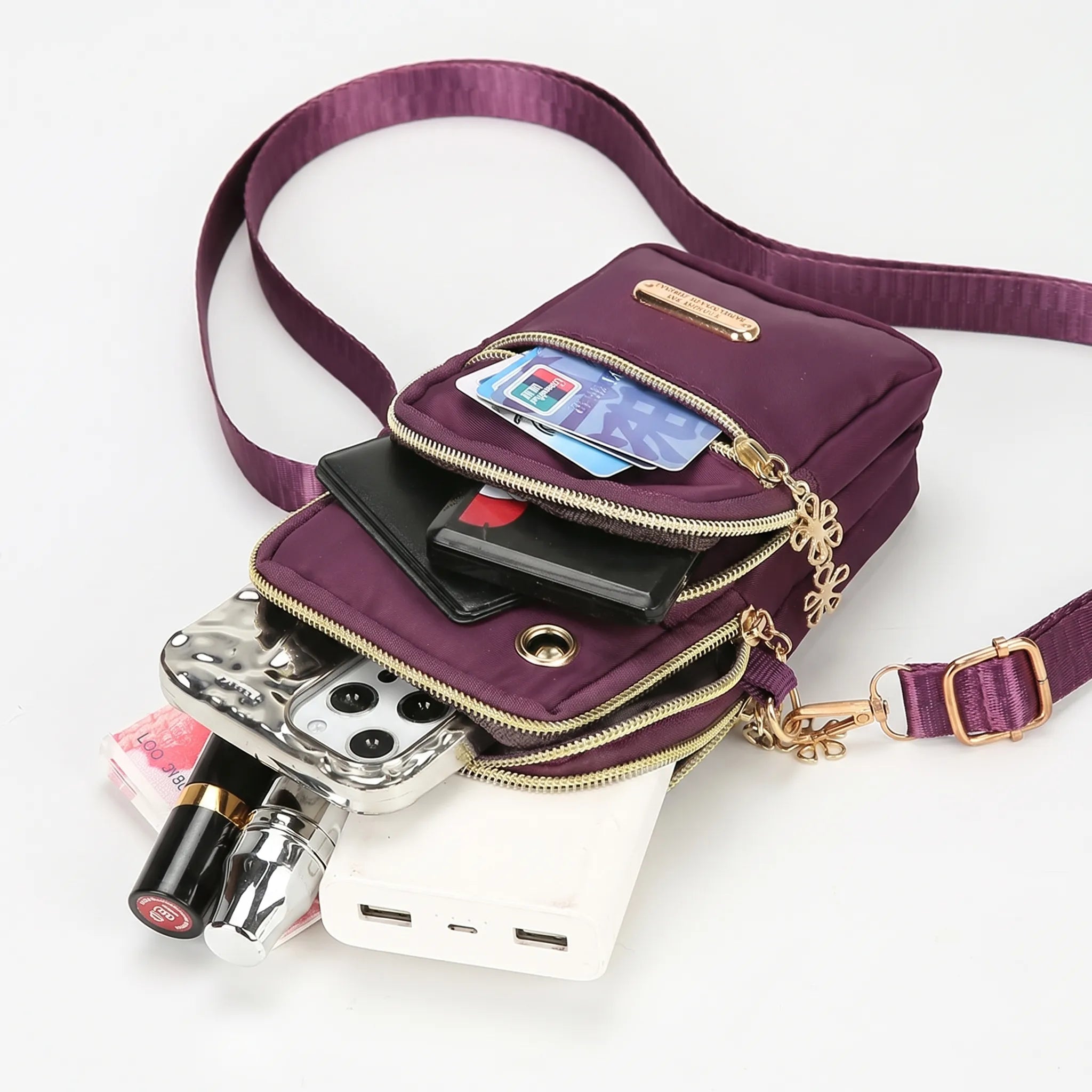 Compact crossbody bag with multiple zip pockets and adjustable strap