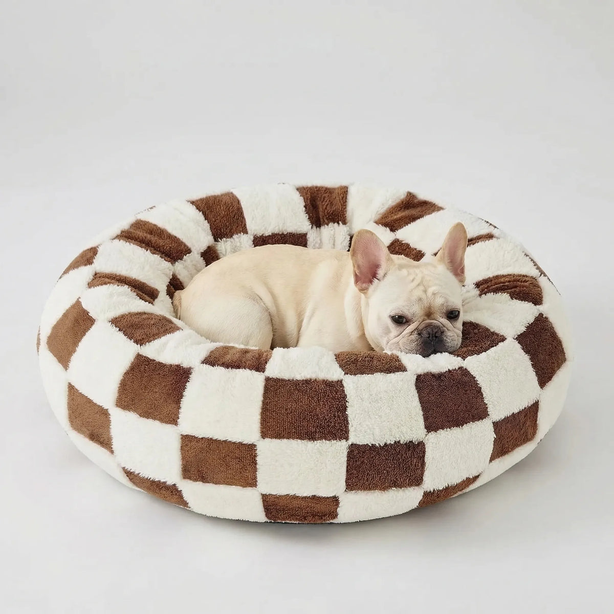 Round plush dog bed with raised bolstered rim, non-slip base, machine-washable