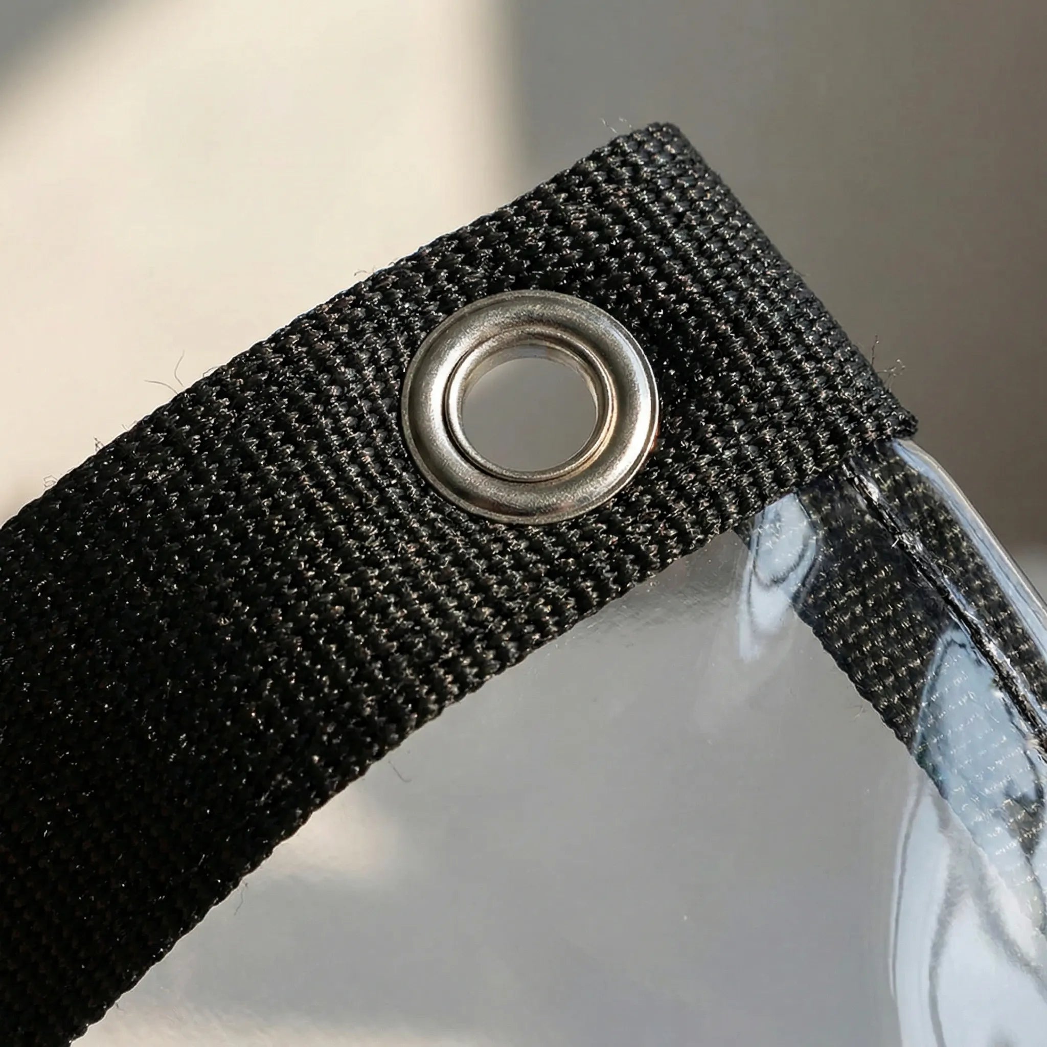 Transparent zipped pergola panel with reinforced edging and metal eyelets