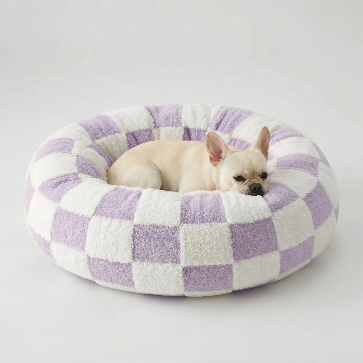 Round plush dog bed with raised bolstered rim, non-slip base, machine-washable